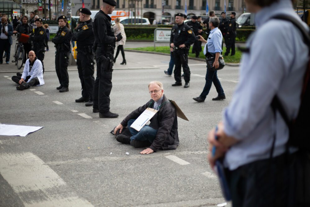 Klimaprotest von Jesuiten Pater Jörg Alt klebt sich bei der Aktion der Scientists Rebellion am Stachus auf der Straße fest Foto Imago/Alexander Pohl